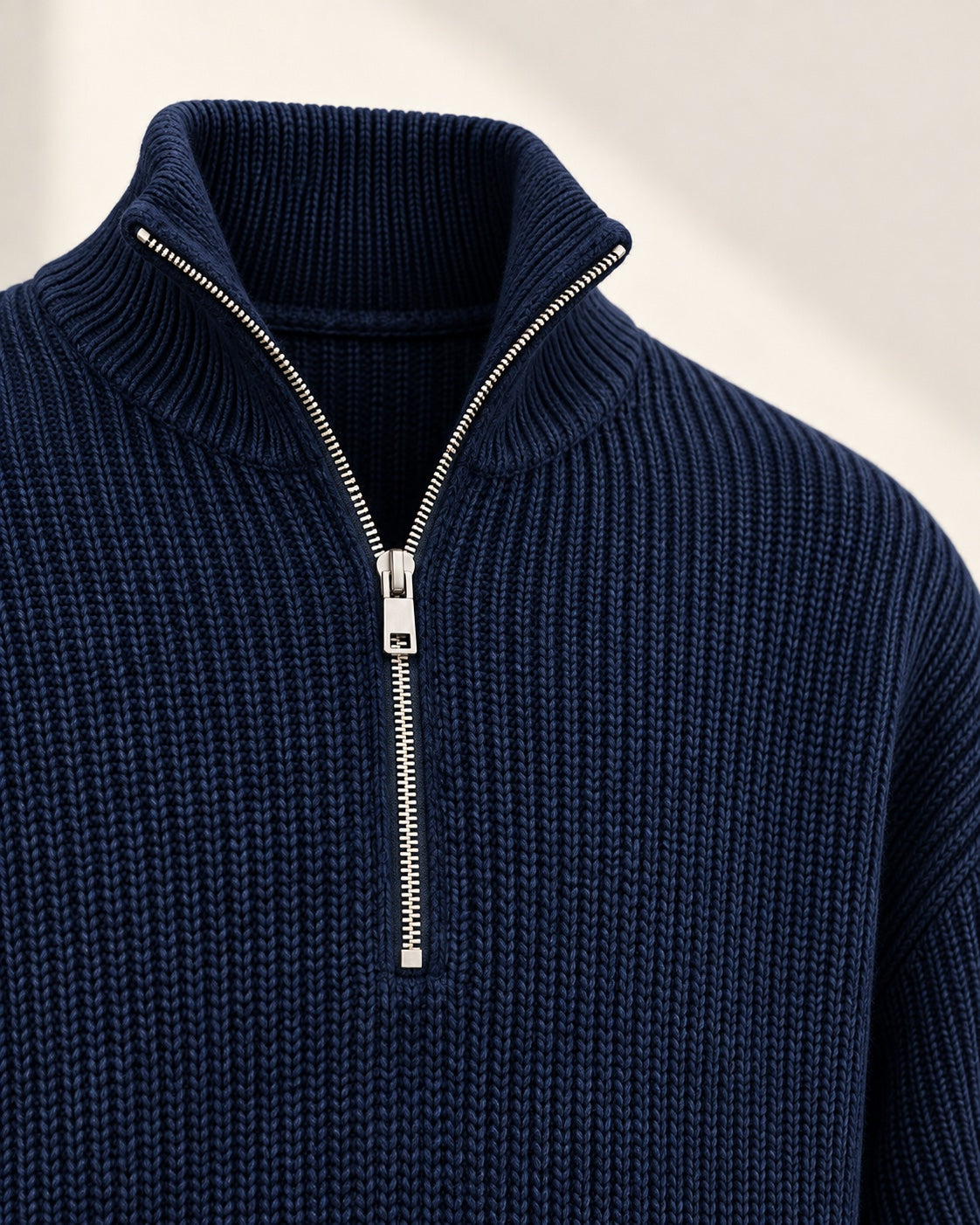 Macro view of the ribbed navy half-zip collar and silver zipper